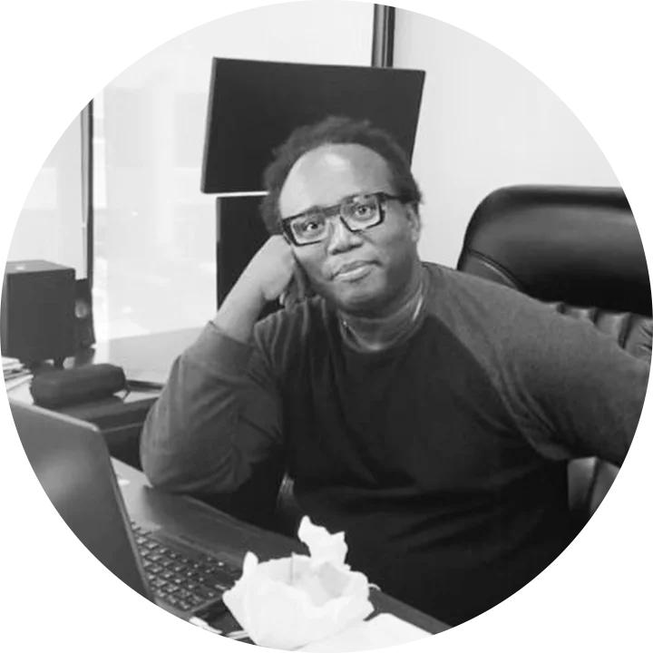 Adler Jean-Baptiste at his desk in the Lighthouse office, with a laptop and a monitor