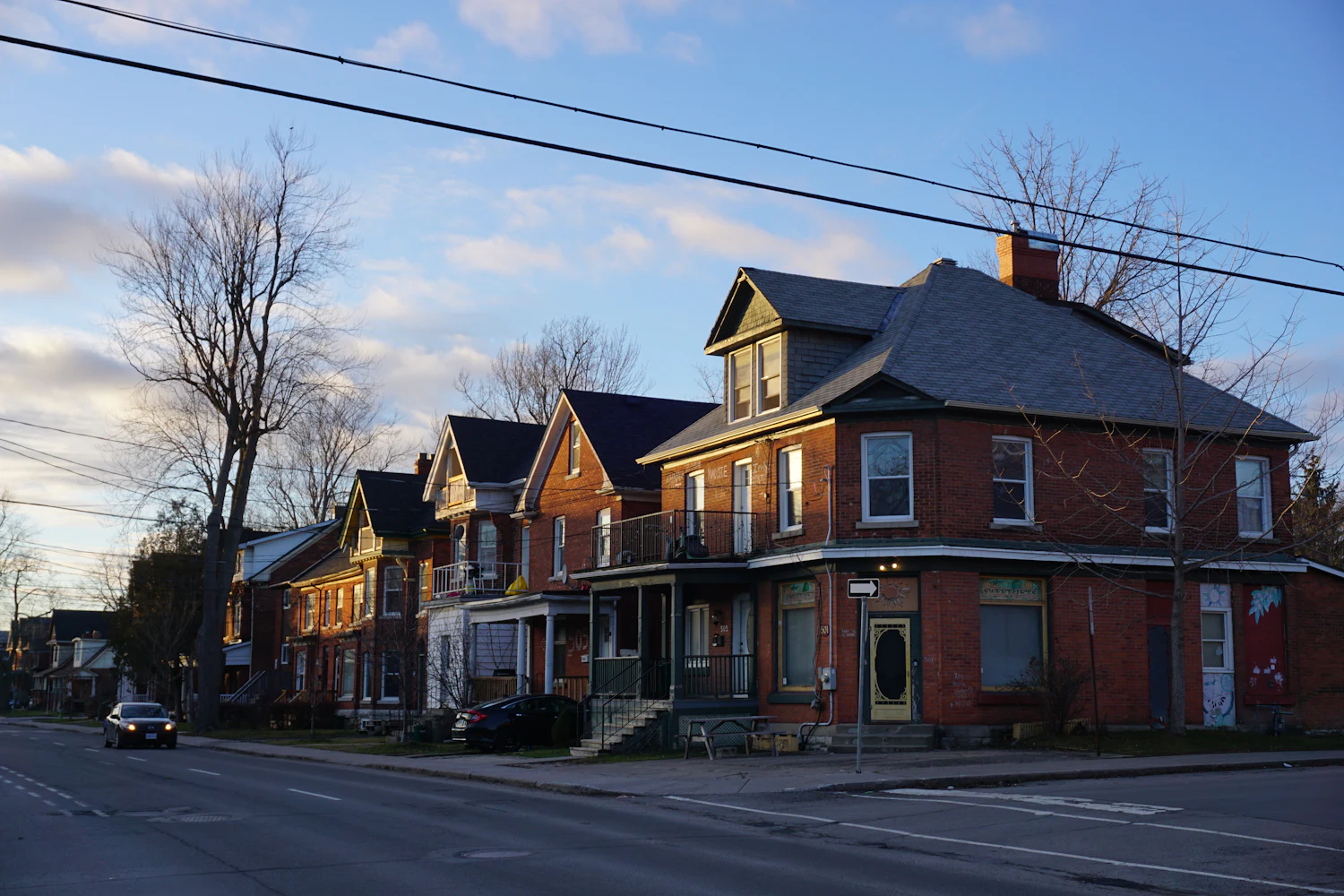 Brick houses and a corner building on a wide city street