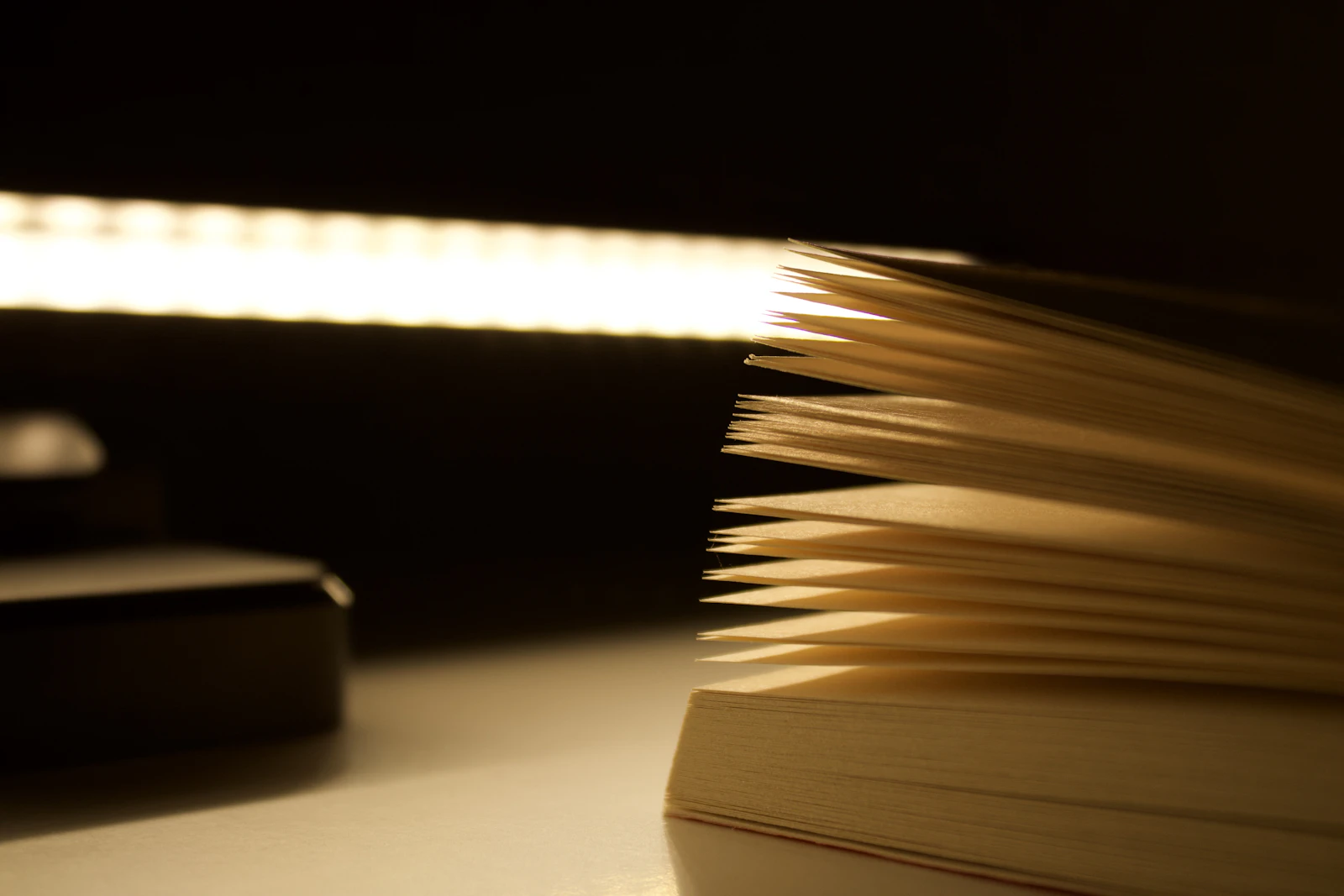An open book on a desk in a dark room